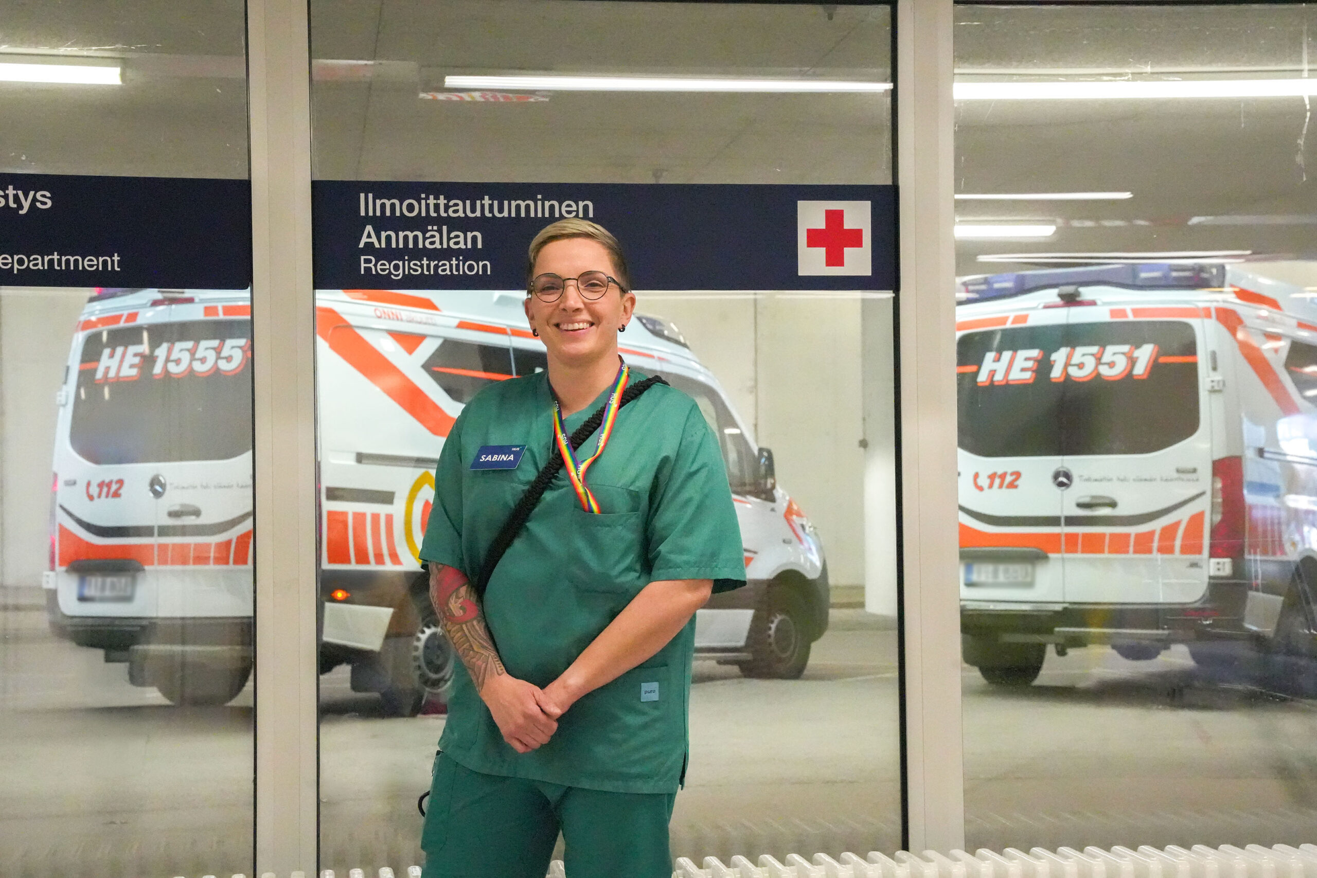 Sabina Holopainen kuvattuna ikkunan edessä, josta näkyy ambulansseja